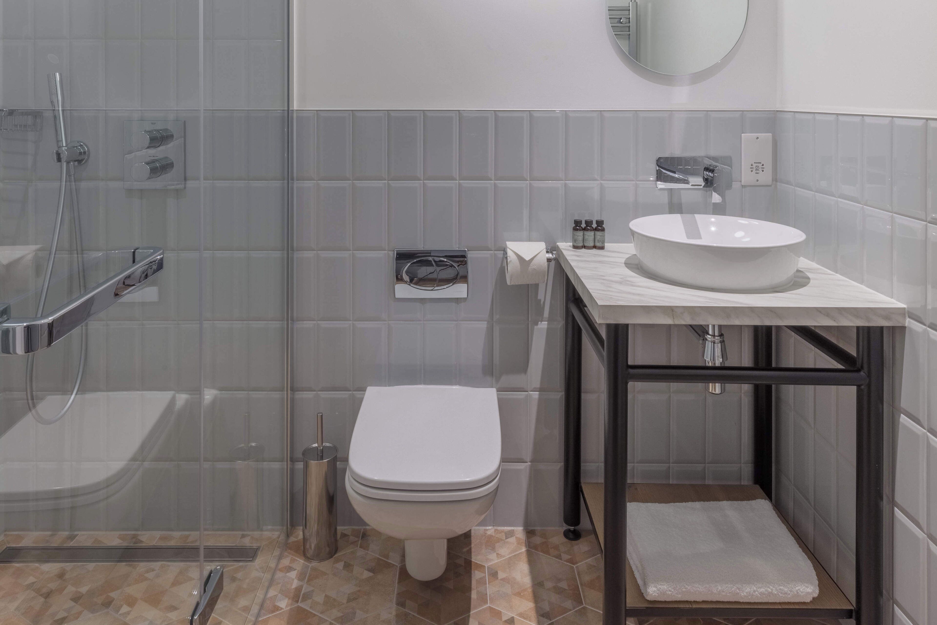 Une salle de bain moderne avec une douche à parois de verre, des toilettes blanches et un meuble-lavabo.
