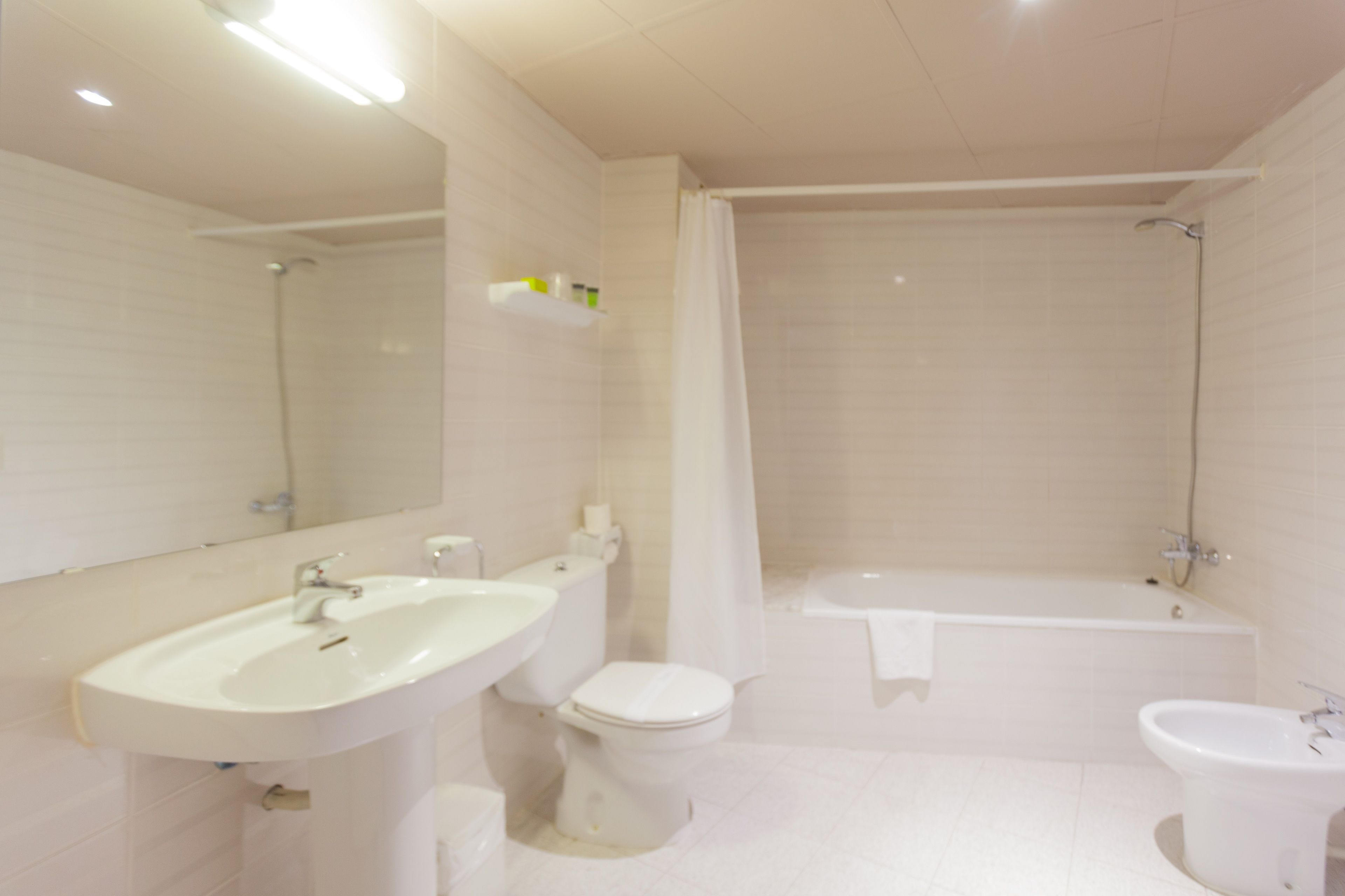 Un baño moderno con lavamanos, inodoro, bañera y bidé.