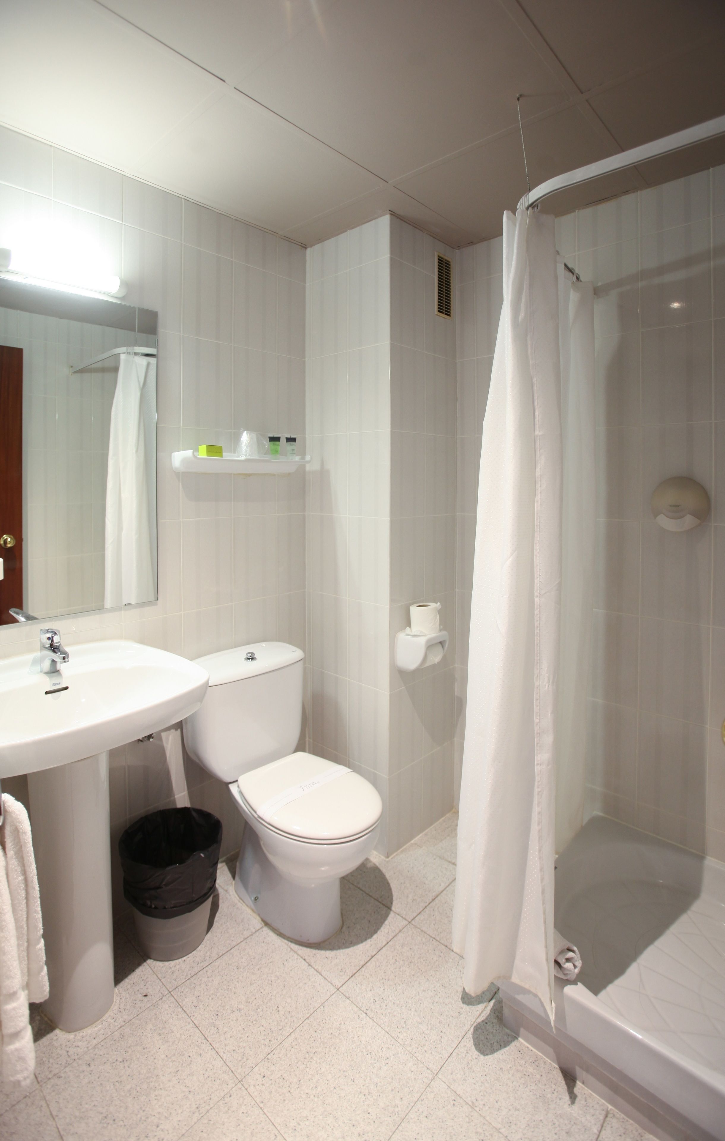 A bathroom with a sink, toilet, and shower.