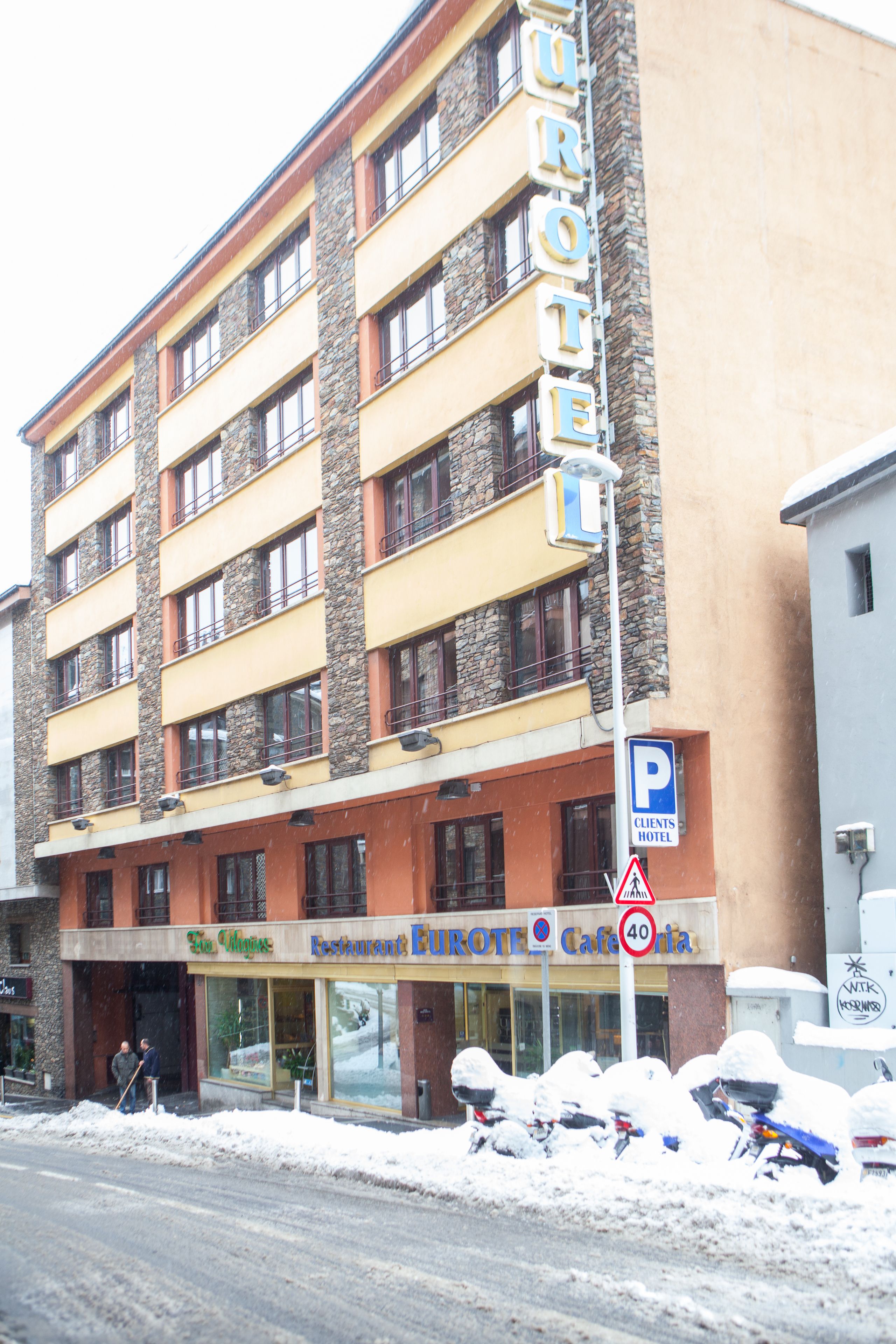 A multi-story hotel with a stone facade and balconies.