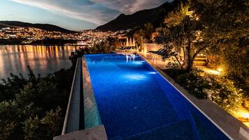 Outdoor pool, an infinity pool, pool umbrellas, sun loungers