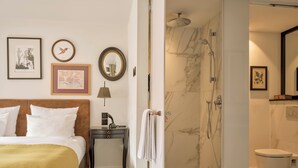 A hotel room with a bed, bedside table, lamp, framed pictures, and a shower area with a toilet. - The Nikolai Hotel Hamburg, Leonardo Limited Edition (Hamburg)