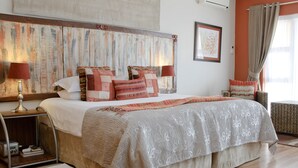 A bedroom with a large bed, two bedside tables, a headboard, and a window with curtains. - Country Park (Muldersdrift)