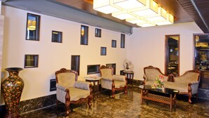 A lobby with a marble floor, a sofa set, a coffee table, and a large vase. - Visitel - A Boutique Hotel (Kolkata)