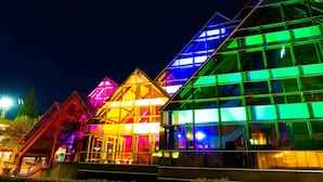 Un bâtiment doté de nombreuses structures triangulaires illuminées de lumières colorées.