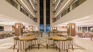 A spacious, modern hotel lobby with multiple dining areas, a central atrium, and a view of the sky. - Prodigy Gramado by Wish (Gramado)