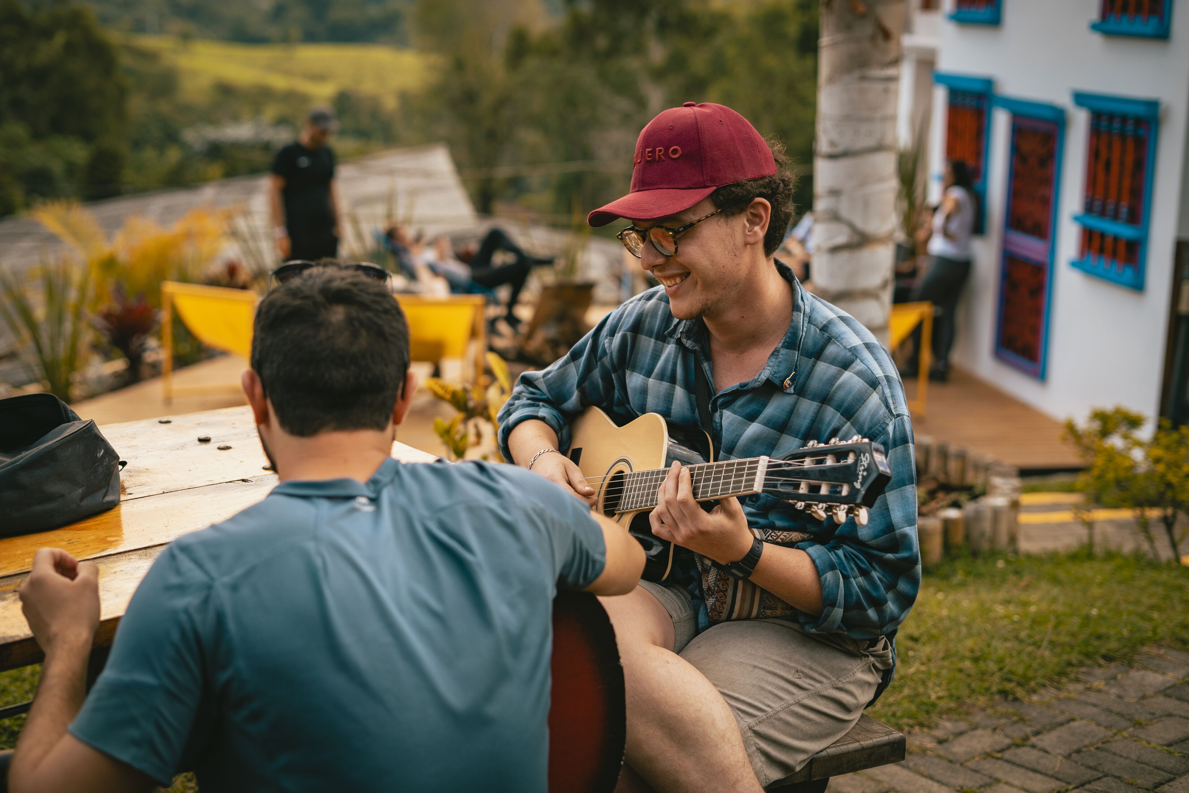 Una persona tocando la guitarra en una mesa al aire libre.