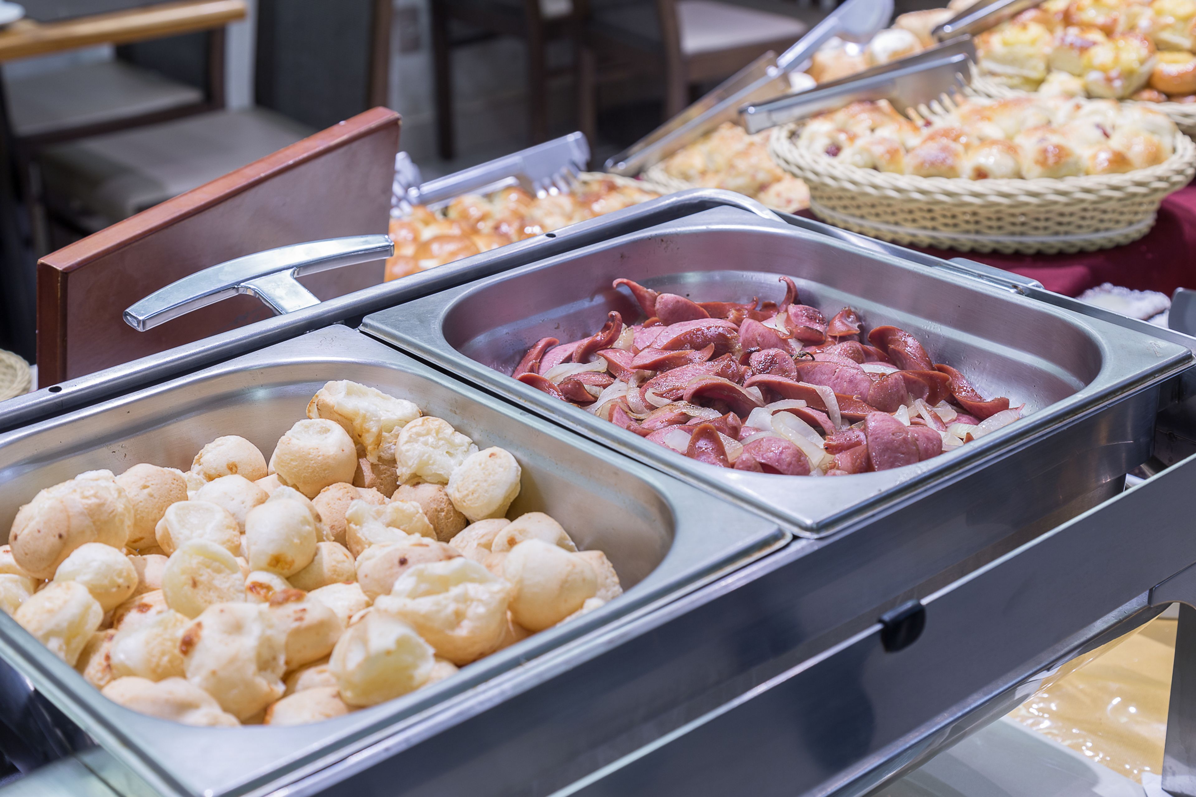 A buffet with various food items including bread, sausages, and cheese.