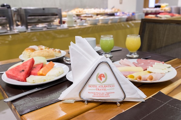 A breakfast buffet with various food items and a napkin holder with the hotel's name.