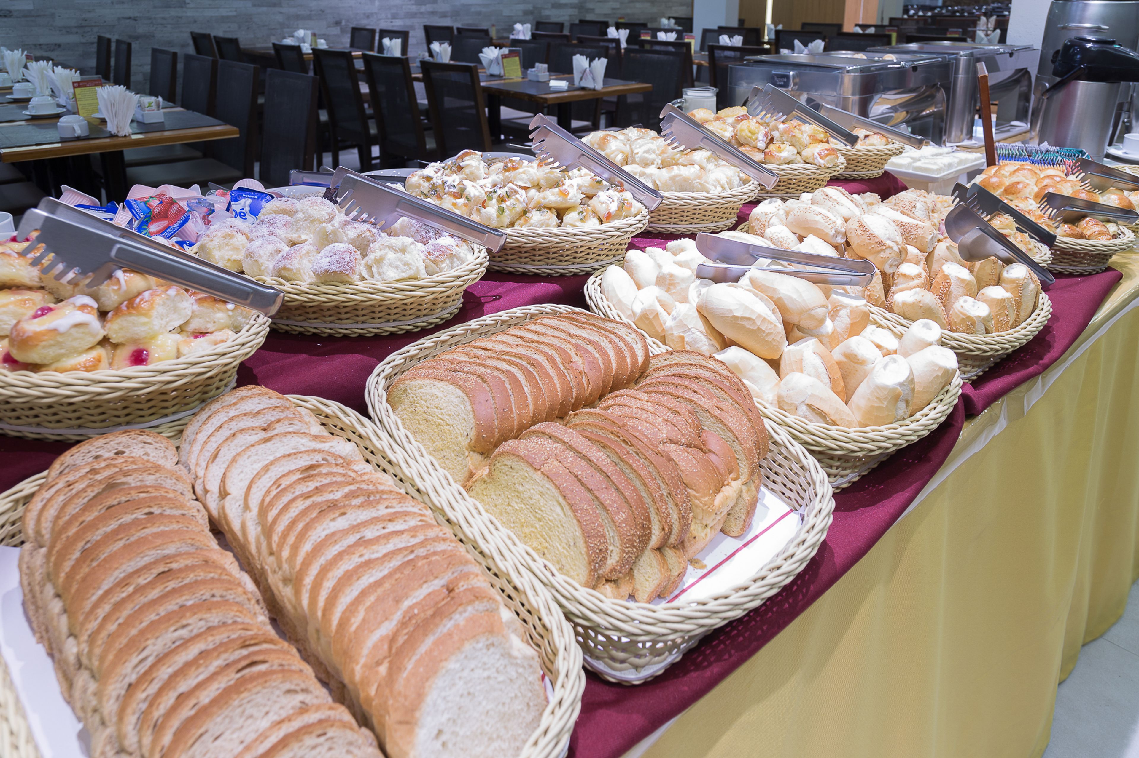 A buffet with various breads and pastries.