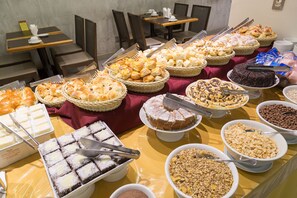 Un buffet proposant une variété de plats et d’ustensiles de service.