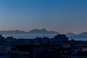 Un paysage urbain côtier, avec des bâtiments et des montagnes en arrière-plan.