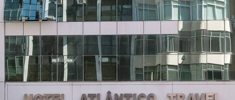Un edificio moderno con un cartel que dice "HOTEL ATLÂNTICO TRAVEL".