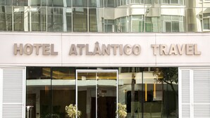 Un hotel moderno con fachada de vidrio y el nombre 
