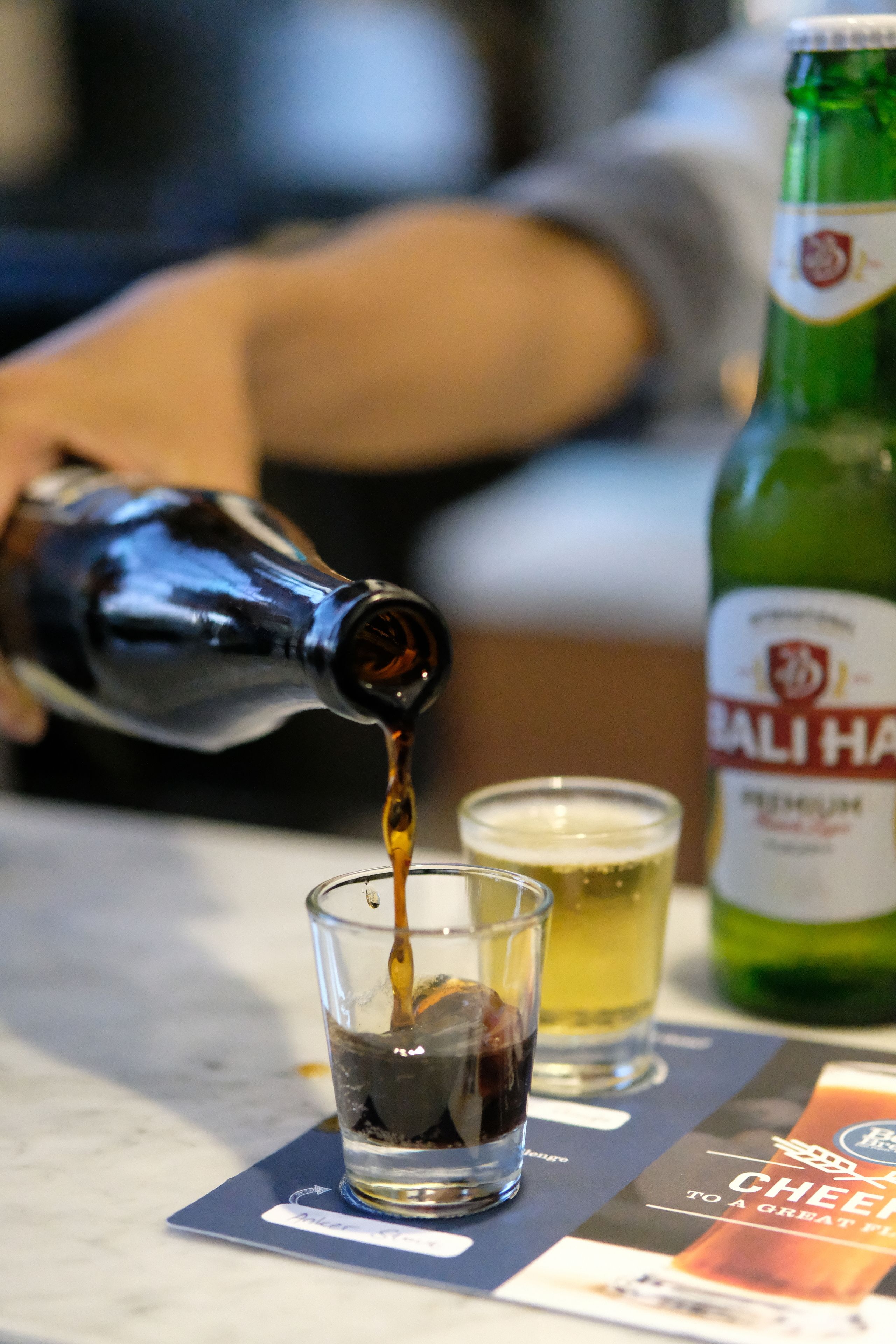 A bottle of beer being poured into a glass.