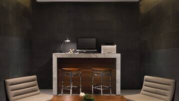 A modern room with a dark wall, a wooden table, two bar stools, a flat-screen TV, and a small white cabinet.