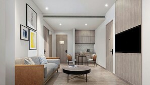 Una sala de estar moderna con un sofá, una mesa de centro y un televisor de pantalla plana montado en la pared.
