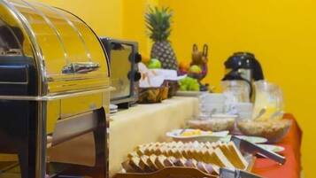 A buffet setup with various food items and a grill.