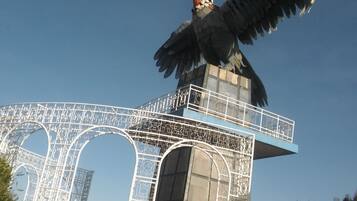Una gran escultura de ave sobre una estructura con ornamentación metálica detallada.