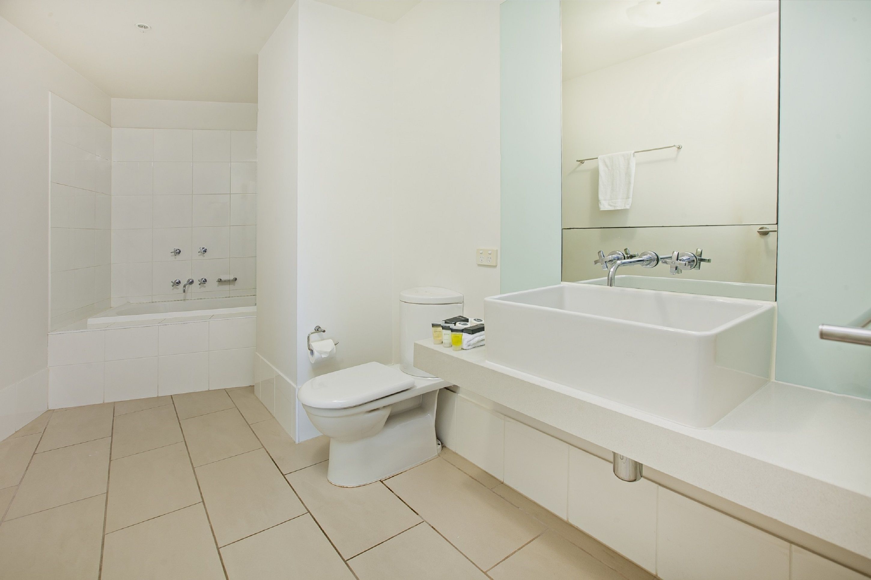 Et moderne badeværelse med badekar, toilet og håndvask.