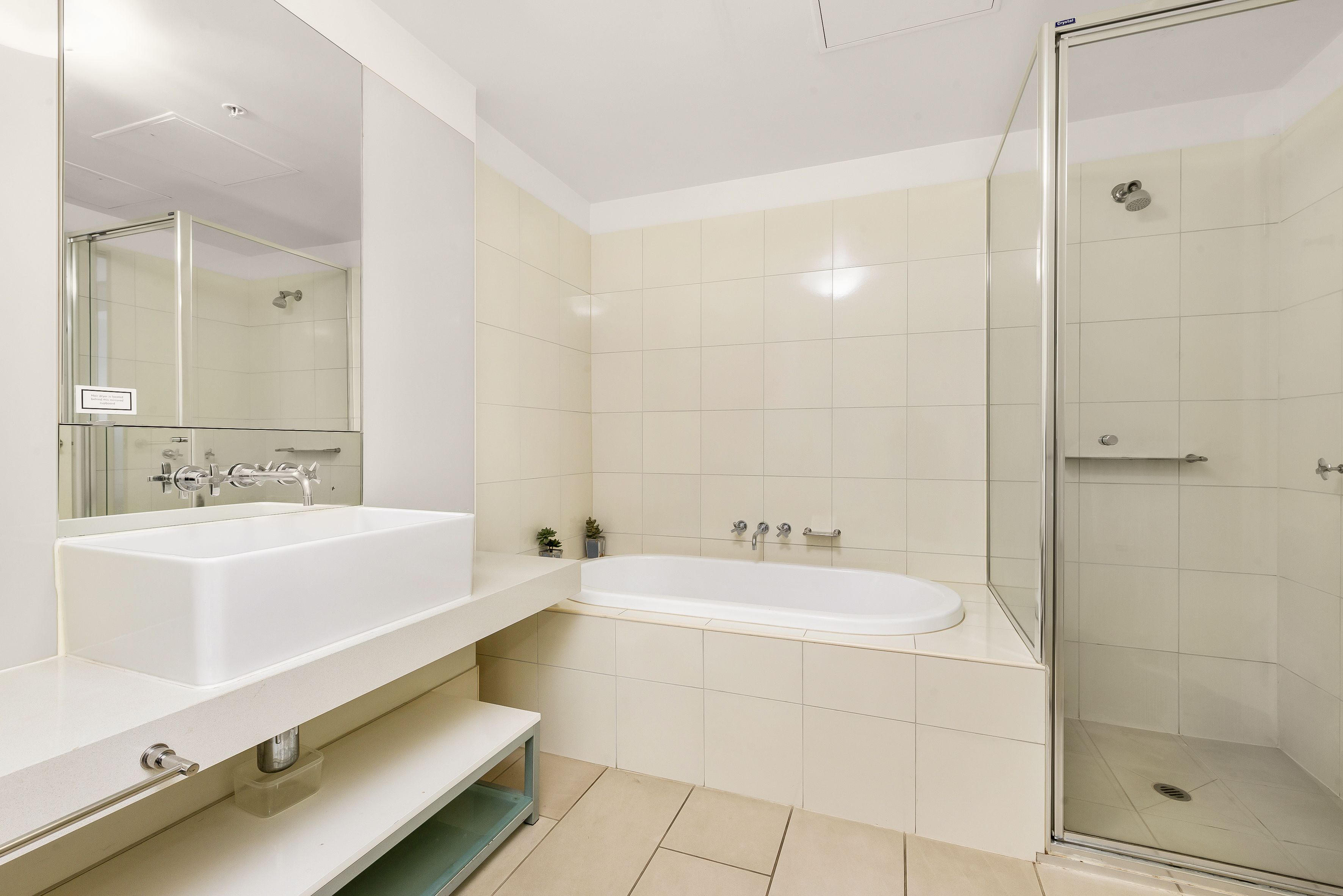Ein modernes Badezimmer mit einem großen, weißen Waschbecken, einer Badewanne und einer Duschkabine.