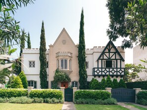 A castle-like building with a central tower, a turreted entrance, and a Tudor-style wing. - Atemporal by Andean (Lima)