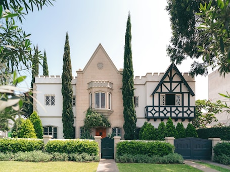 A castle-like building with a central tower, a turreted entrance, and a Tudor-style wing.