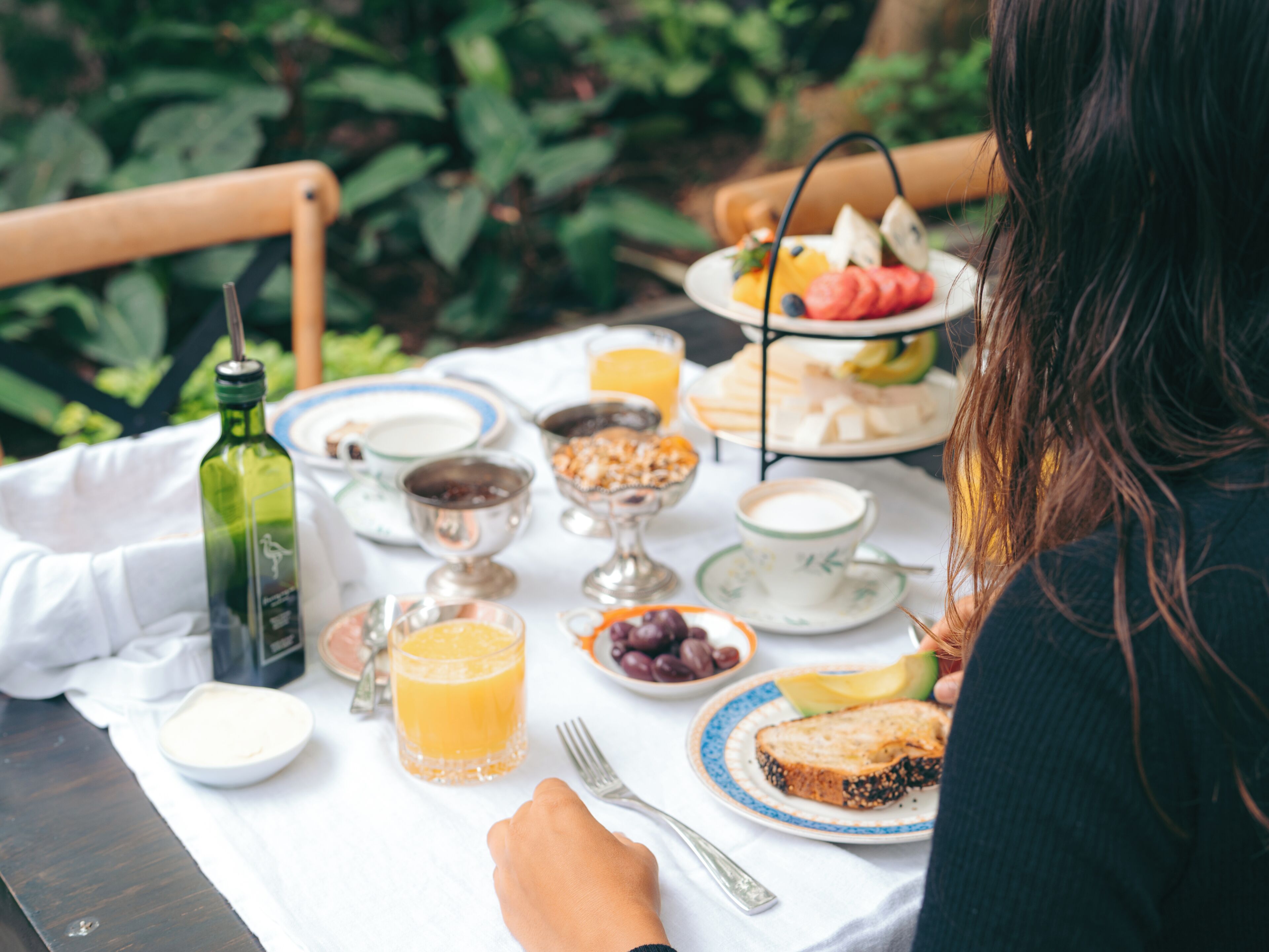 A dining table with various breakfast items, including fruits, bread, and beverages.