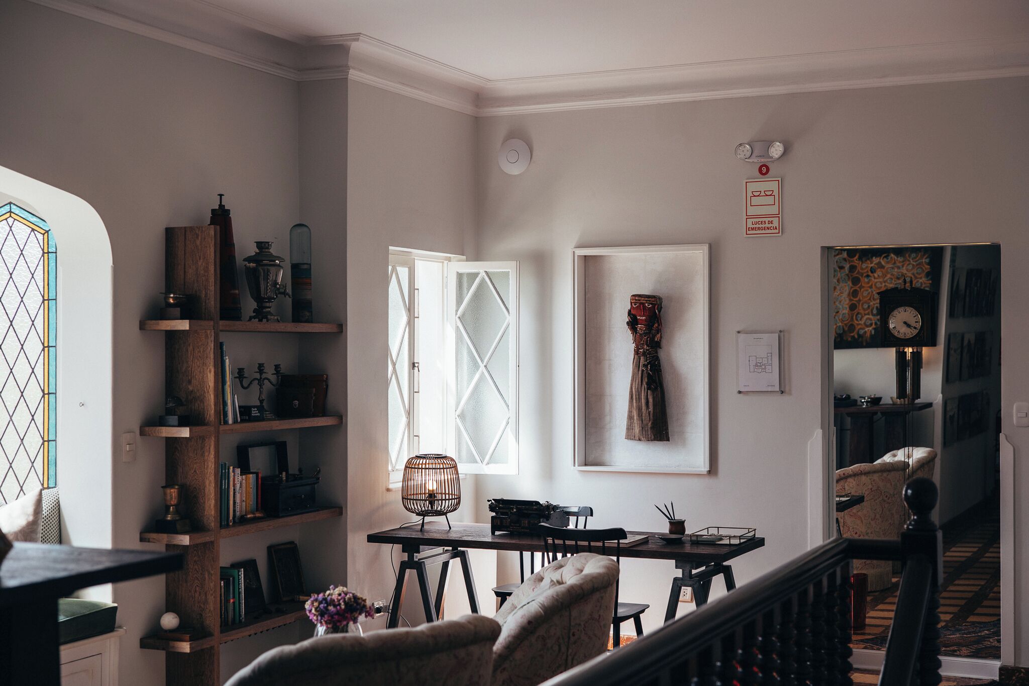 Une pièce comprenant une table à manger, des chaises, une bibliothèque, une fenêtre et un escalier.