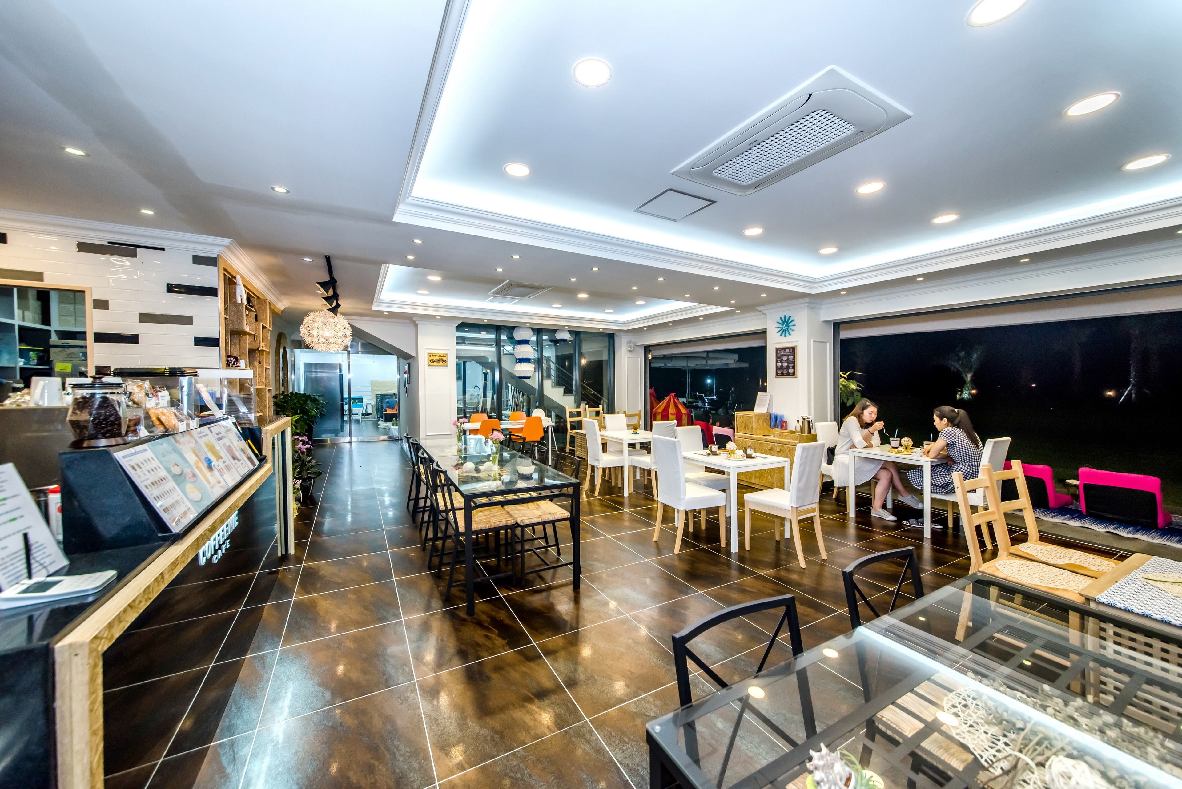 Un restaurante moderno con una distribución amplia, una barra de servicio central y diversas opciones de asientos, incluyendo mesas y sillas.