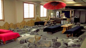 Una habitación con suelo de piedra, varias zonas de estar y un mostrador de recepción.