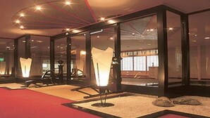 Un interior moderno con divisiones de vidrio, alfombra roja y diseño minimalista.