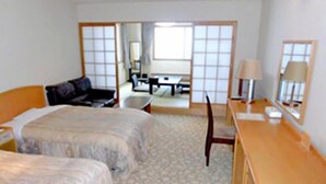 Una habitación de hotel con cama, escritorio, silla y espejo.