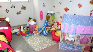 Playful space for kids with a playhouse, play mat, and toys.