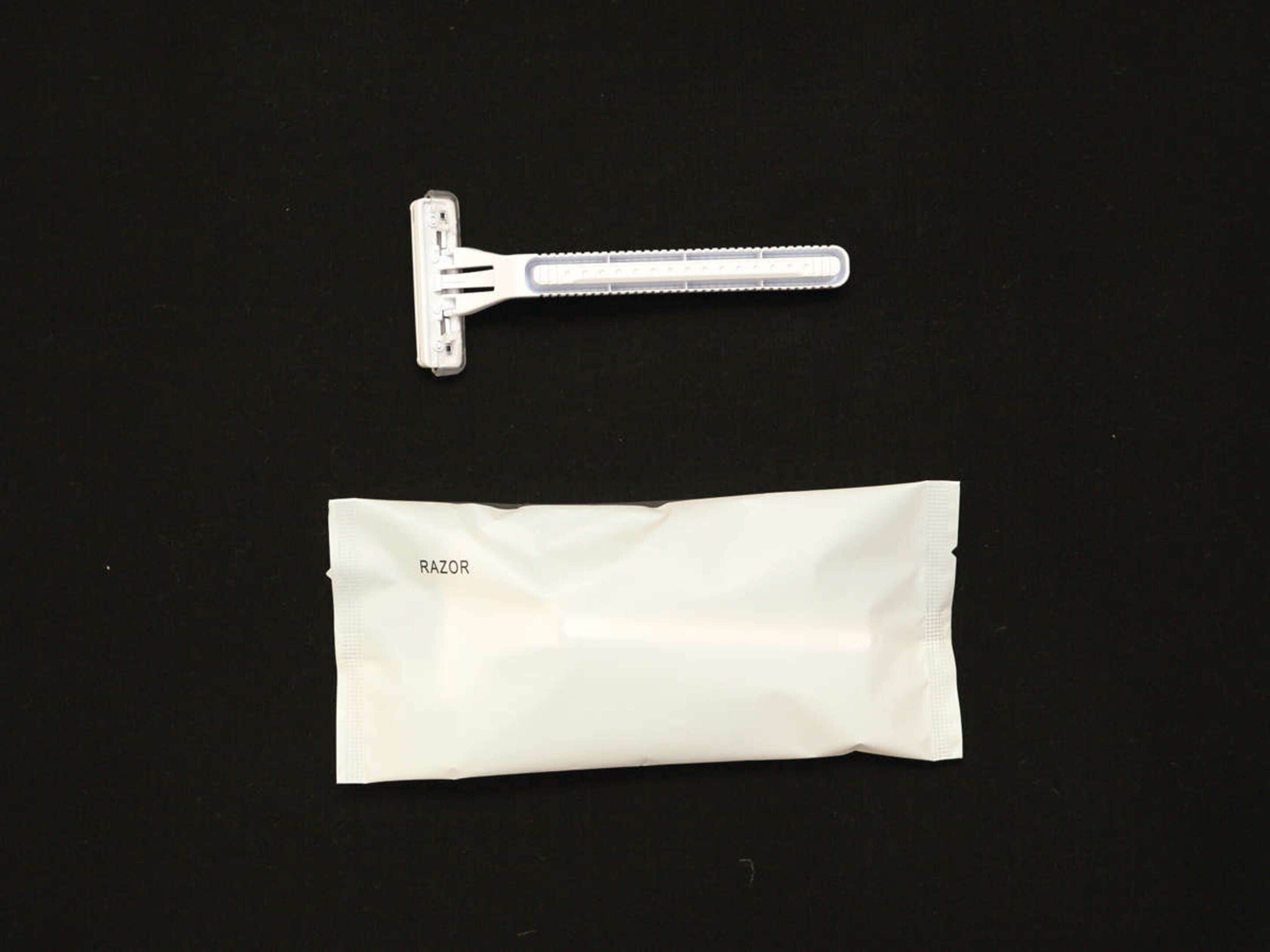 A razor and a razor blade package on a black background.