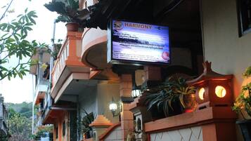 Een bordje voor 'HARMONY Guest House' met contactgegevens en een website URL.