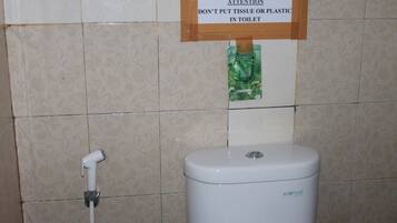 Un inodoro con un letrero encima que dice: "ATENCIÓN NO TIRE PAPEL NI PLÁSTICO AL INODORO".
