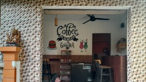 Entrada a una cafetería con un letrero que dice "Coffee Always Good Idea".