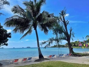 Trên bãi biển, ghế dài tắm nắng, dù trên bãi biển, khăn tắm biển 