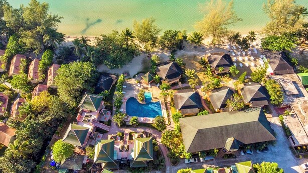 An aerial view of a resort with multiple bungalow-style accommodations, a central swimming pool, and a beach area. - Coconut Beach Resort (Ko Chang)