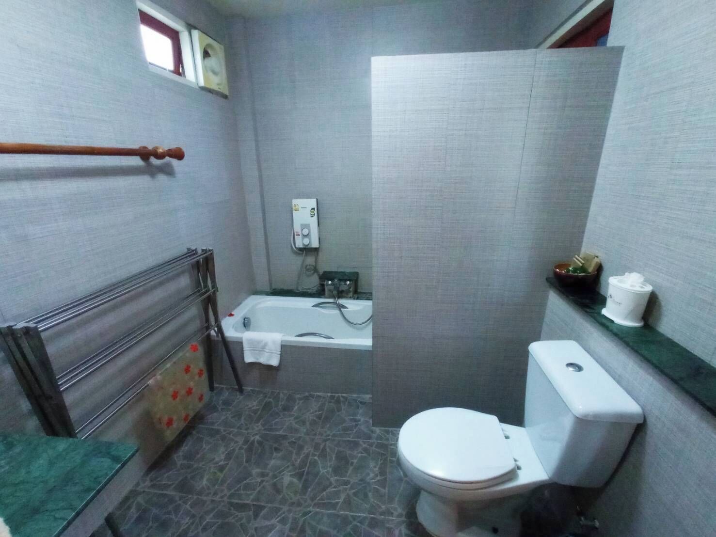 A bathroom with a bathtub, toilet, and shower.