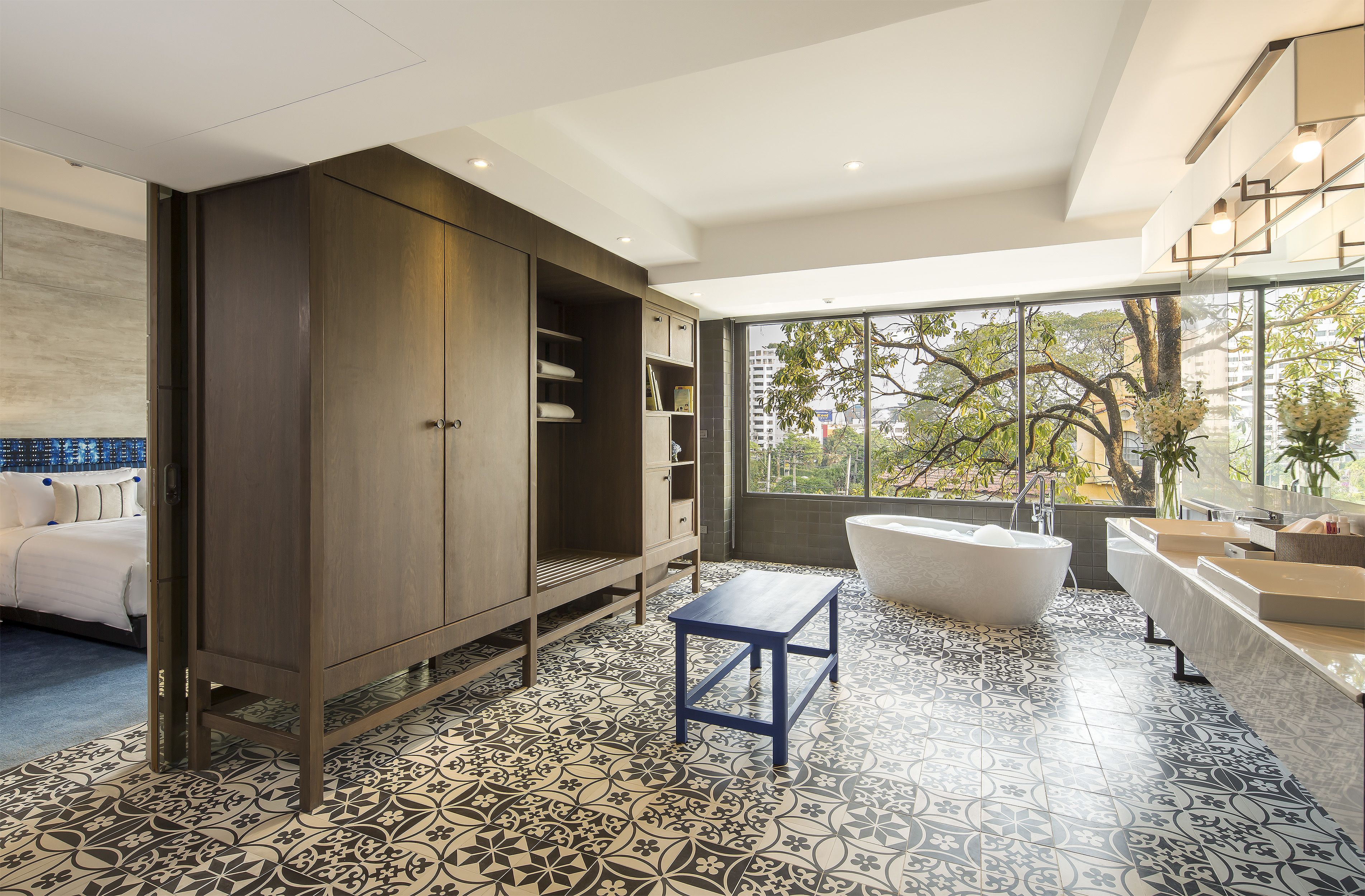 A modern bathroom with a freestanding bathtub, a large vanity, and a walk-in closet.