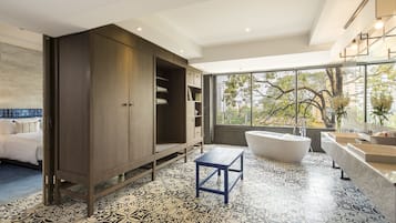A modern bathroom with a freestanding bathtub, a large vanity, and a walk-in closet.