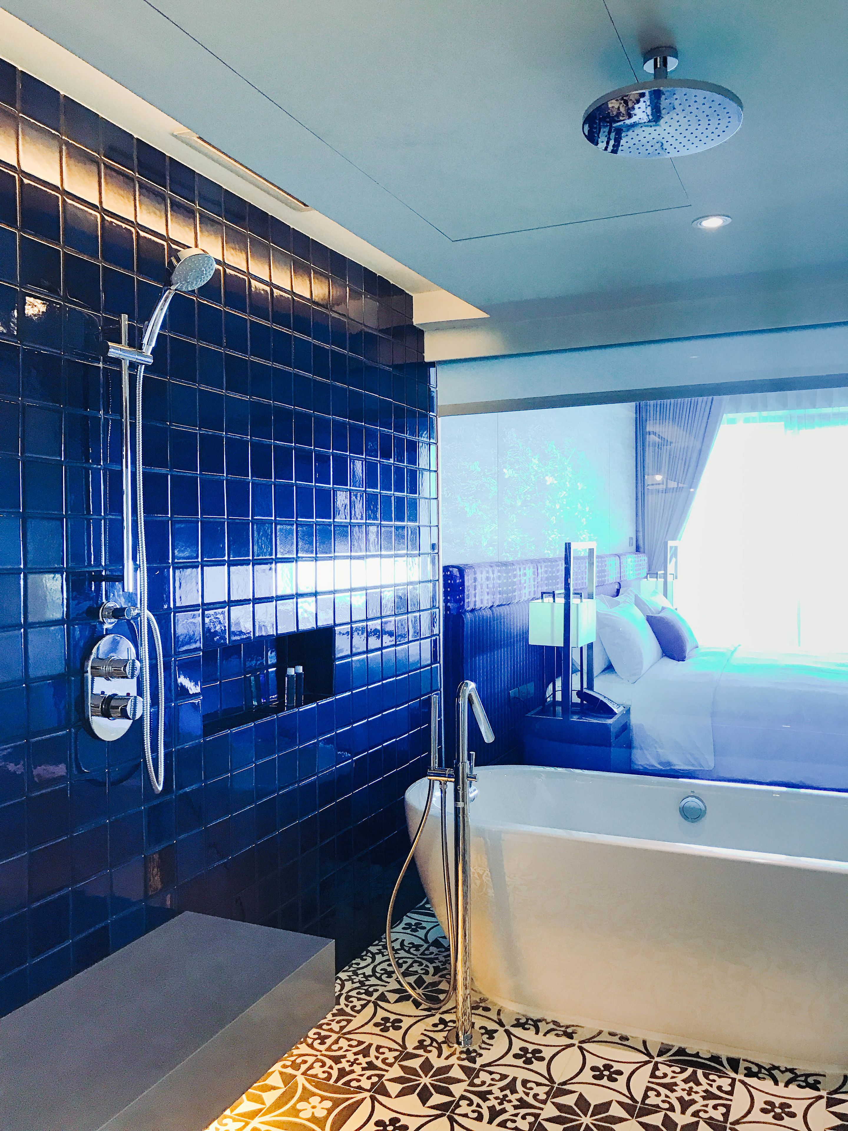 Un baño moderno con una bañera grande, zona de ducha y ventana con vistas al exterior.
