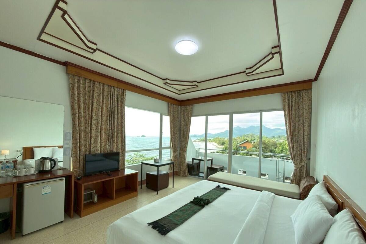 Una habitación de hotel con cama, escritorio, televisión y minibar.