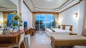 Una habitación de hotel con balcón, cama, escritorio y zona de comedor.