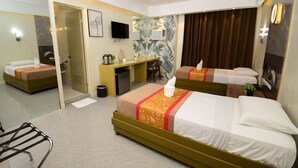 Une chambre d’hôtel avec deux lits, un bureau, une chaise, un miroir, une télévision et un espace douche.