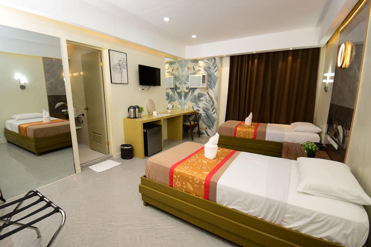 Hotelkamer met twee bedden, een bureau, een stoel, een spiegel, een televisie en een douche.