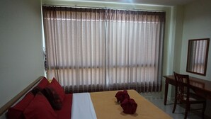 A hotel room with a bed, a red sofa, a wooden desk, and a chair. - GIB Apartment (Surin)
