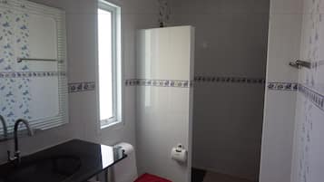 A bathroom with a sink, toilet, and shower.